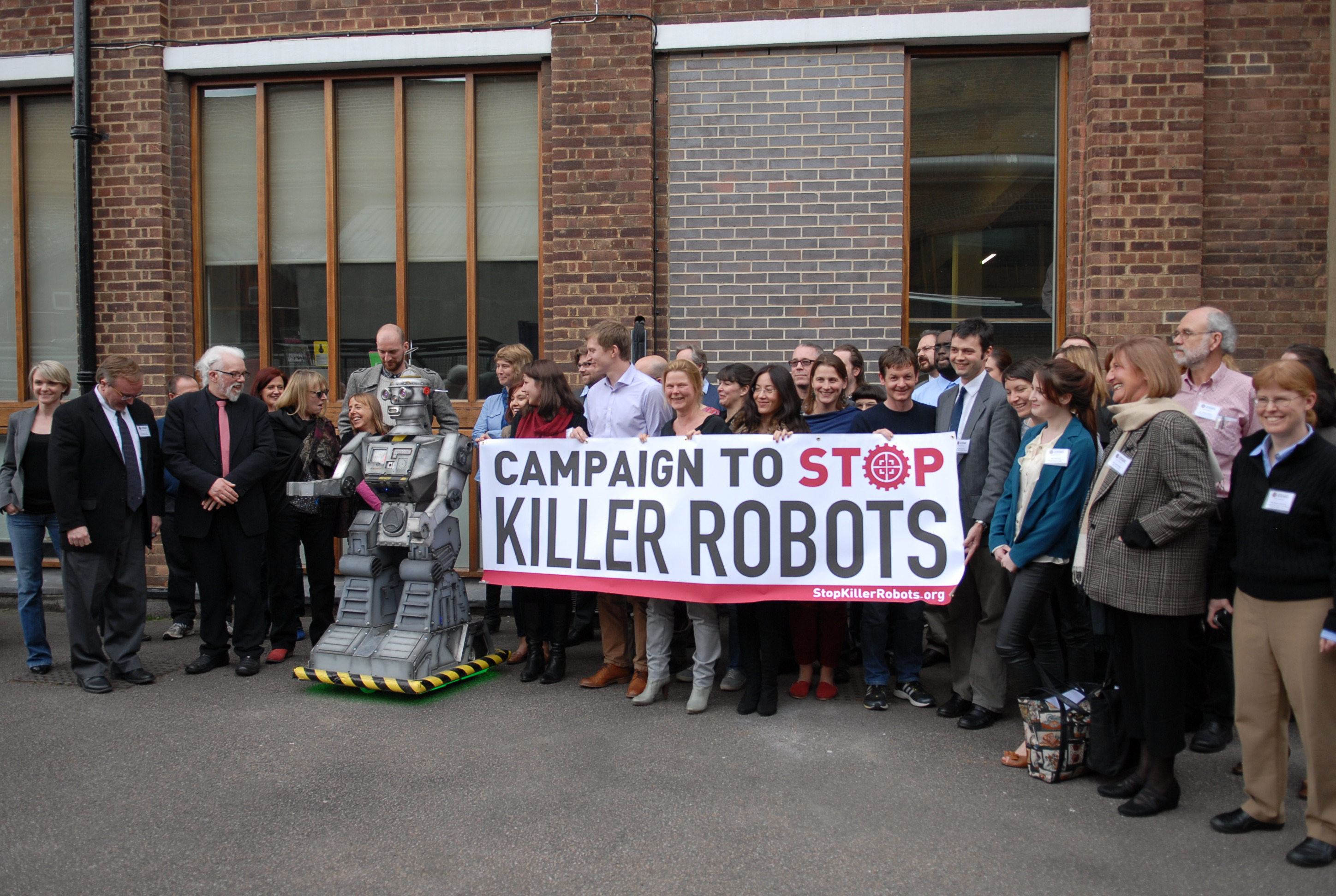 Protestors holding a large banner that reads 'CAMPAIGN TO STOP KILLER ROBOTS'.